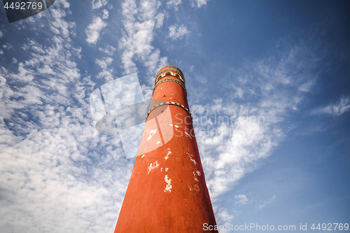 Image of Tall red chimney tower under a blue sky