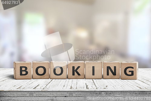 Image of Booking sign on a wooden desk in a room