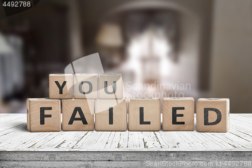 Image of You failed sign on a wooden table in a dark room