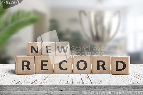 Image of New record sign on a wooden table in a bright room