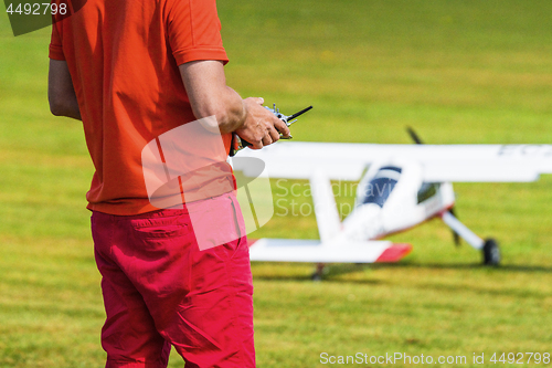 Image of Man flying a model airplane with a controller