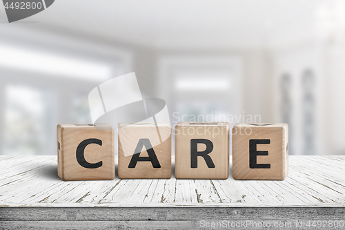 Image of Care sign on a white table in a bright room