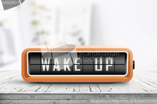 Image of Wake up alarm clock on a table in a bright room