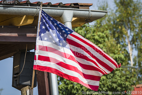 Image of American flag on a porch outside a small cabin