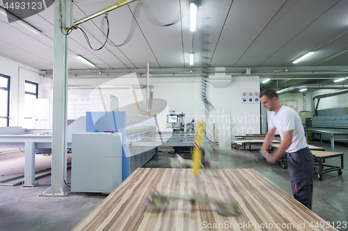 Image of worker in a factory of wooden furniture