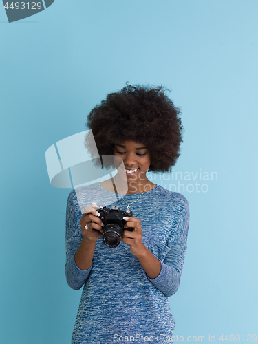 Image of african american girl taking photo on a retro camera