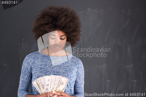 Image of black woman holding money on gray background