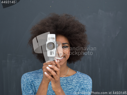 Image of african american woman using a retro video camera