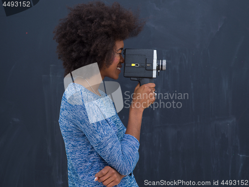 Image of african american woman using a retro video camera