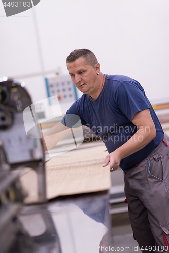 Image of worker in a factory of wooden furniture