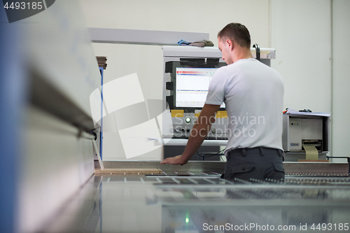 Image of worker in a factory of wooden furniture