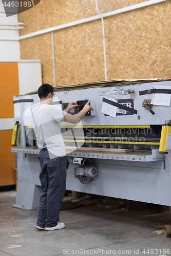 Image of worker in a factory of wooden furniture