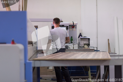 Image of worker in a factory of wooden furniture