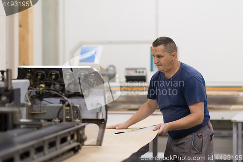 Image of worker in a factory of wooden furniture