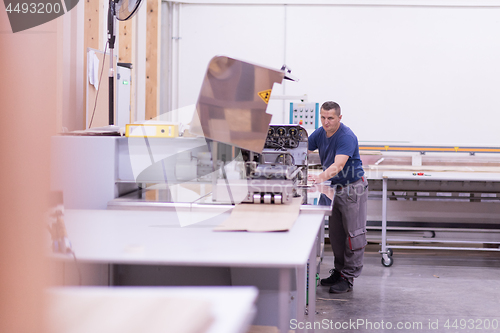 Image of worker in a factory of wooden furniture