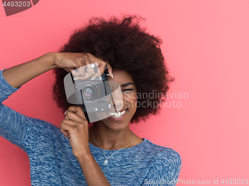 Image of young black girl taking photo on a retro camera