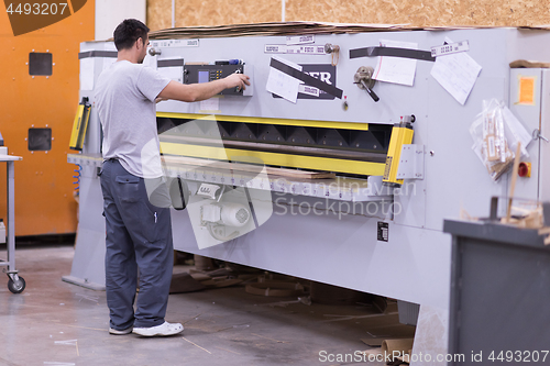 Image of worker in a factory of wooden furniture