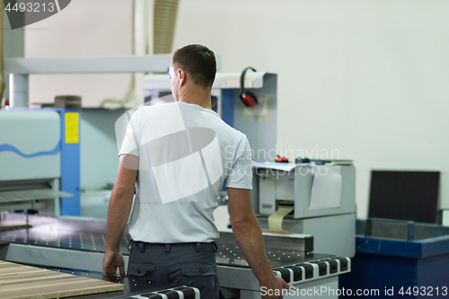 Image of worker in a factory of wooden furniture