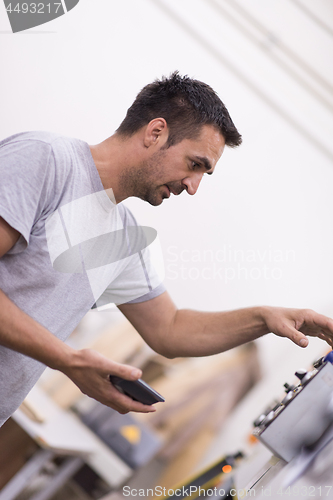 Image of engineer in front of wood cutting machine