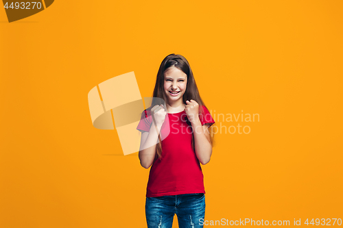 Image of Portrait of angry teen girl on a orange studio background