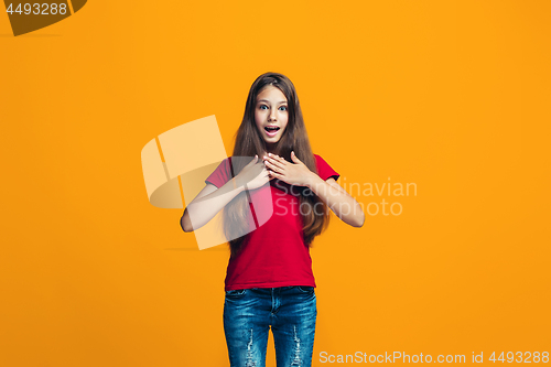 Image of Beautiful teen girl looking suprised isolated on orange