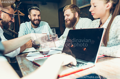 Image of Young cheerful people smile and gesture while relaxing in pub.