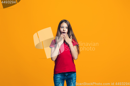 Image of Beautiful teen girl looking suprised isolated on orange