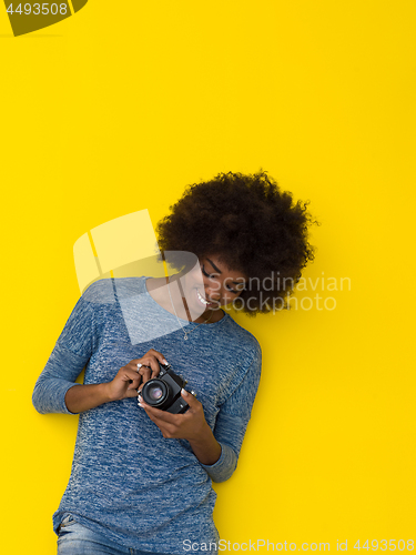 Image of young african american girl taking photo on a retro camera