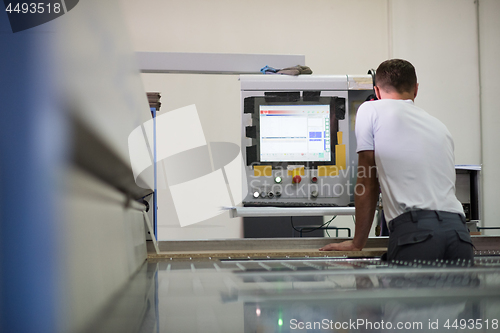 Image of worker in a factory of wooden furniture