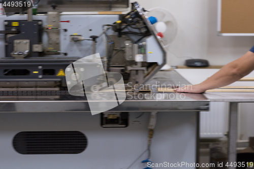 Image of engineer in front of wood cutting machine