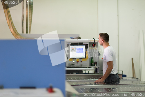 Image of worker in a factory of wooden furniture