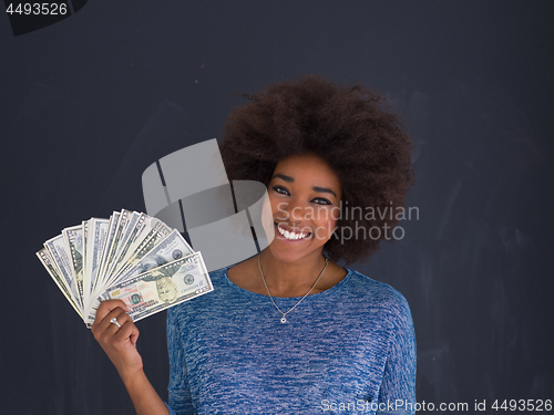 Image of black woman holding money on gray background