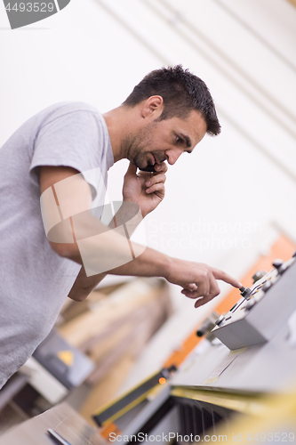 Image of engineer in front of wood cutting machine