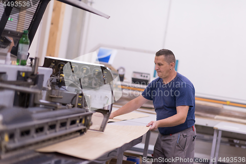 Image of worker in a factory of wooden furniture