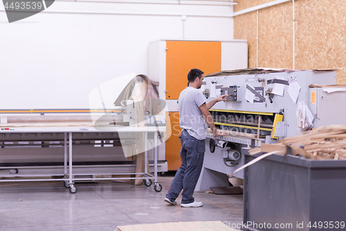 Image of worker in a factory of wooden furniture