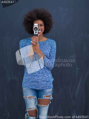 Image of african american woman using a retro video camera