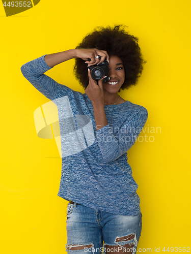 Image of young african american girl taking photo on a retro camera