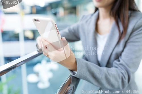 Image of Businesswoman working on mobile phone at outdoor