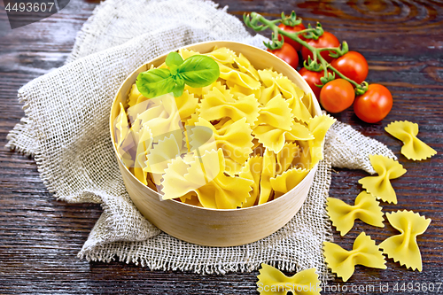 Image of Farfalle in bark box with basil on board