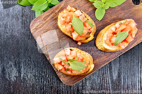 Image of Bruschetta with tomato and basil on board top