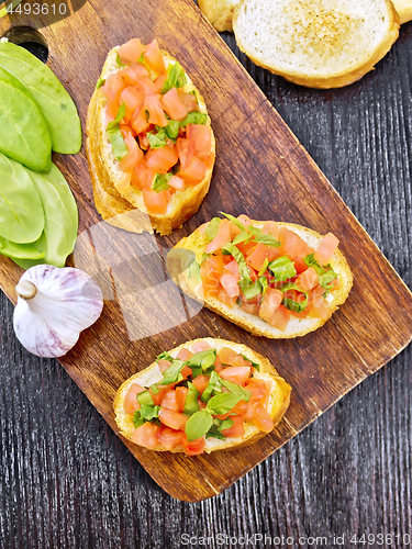 Image of Bruschetta with tomato and spinach on board top