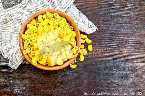 Image of Elbow macaroni in bowl on board top