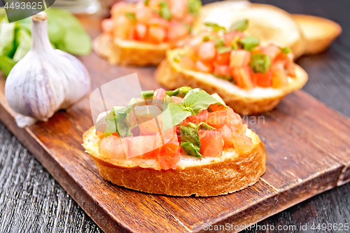 Image of Bruschetta with tomato and spinach on board