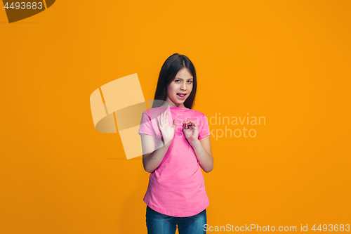 Image of Doubtful pensive teen girl rejecting something against orange background