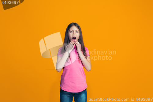 Image of Beautiful teen girl looking suprised isolated on orange