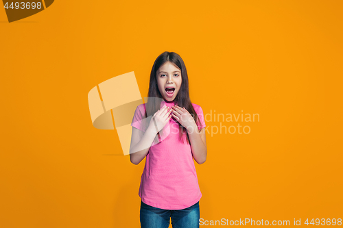 Image of Beautiful teen girl looking suprised isolated on orange