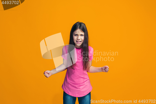 Image of Portrait of angry teen girl on a orange studio background