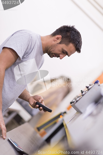 Image of engineer in front of wood cutting machine