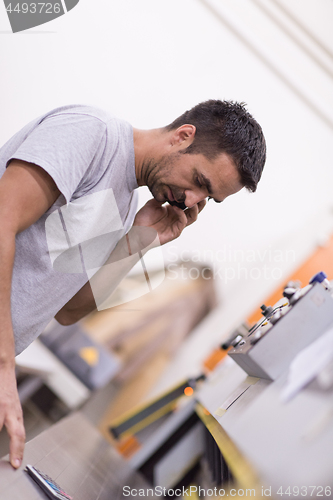 Image of engineer in front of wood cutting machine