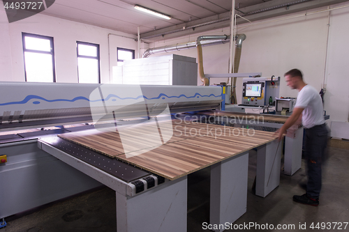 Image of worker in a factory of wooden furniture